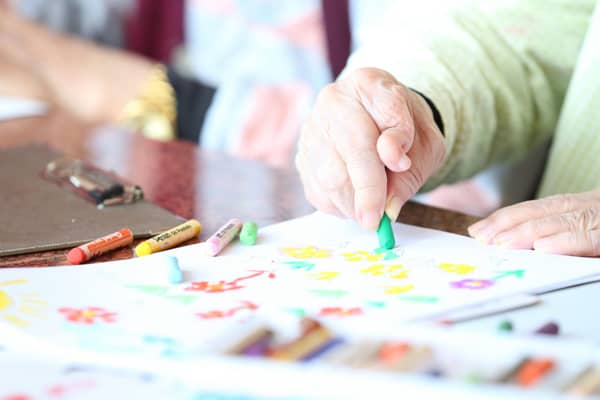 Idős ember rajzol rheumatoid arthritis betegségben szenvedve
